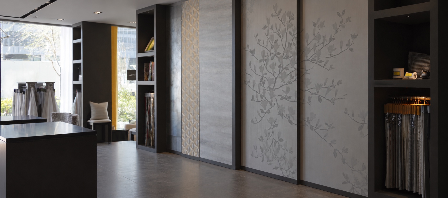 The Tomita showroom: wallcovering panels on sliding boards, sample books and fabrics by the window
