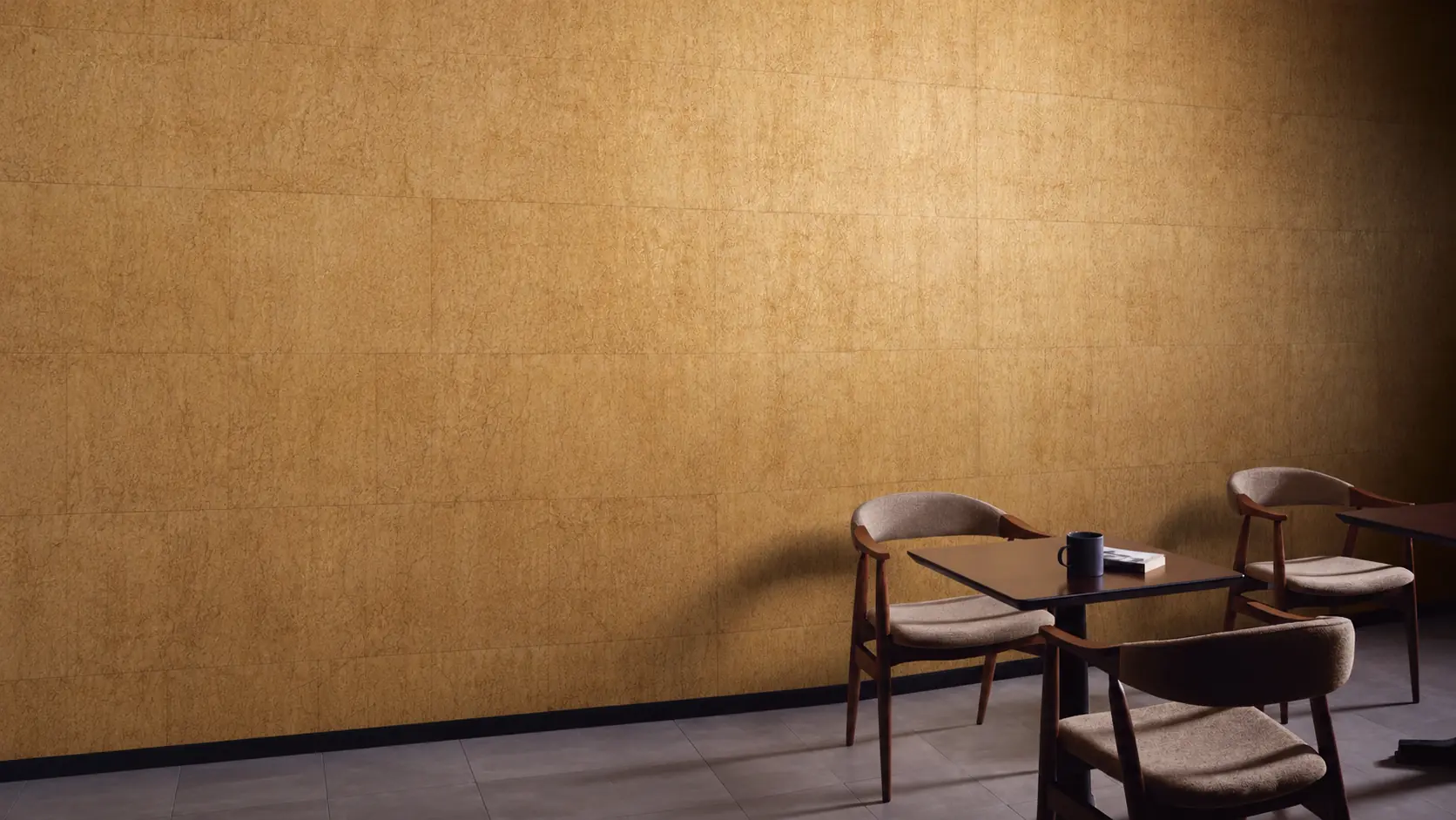 Gold wallcovering with timber chairs and a dark table.