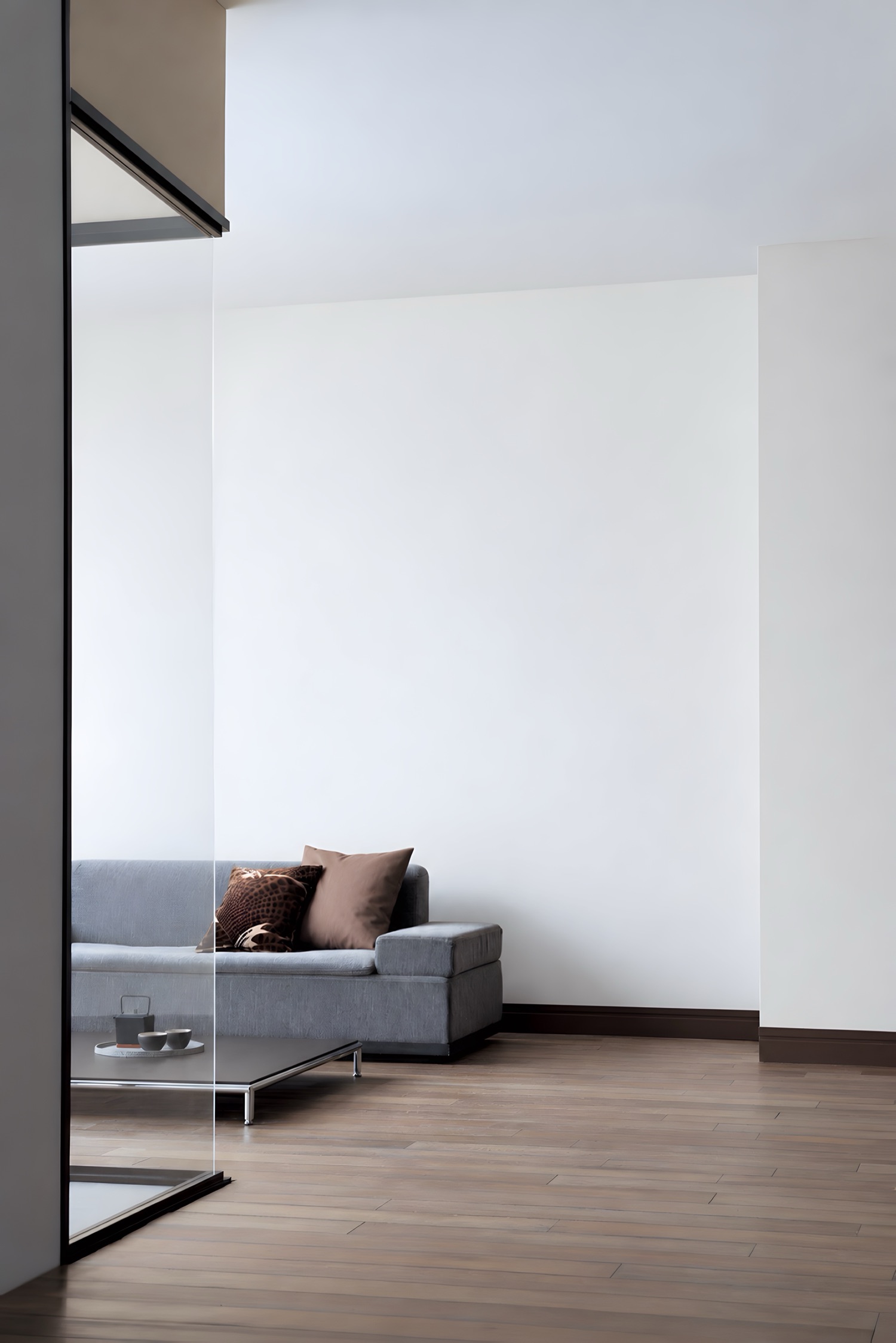 A living room behind a glass partition, the wall painted plain