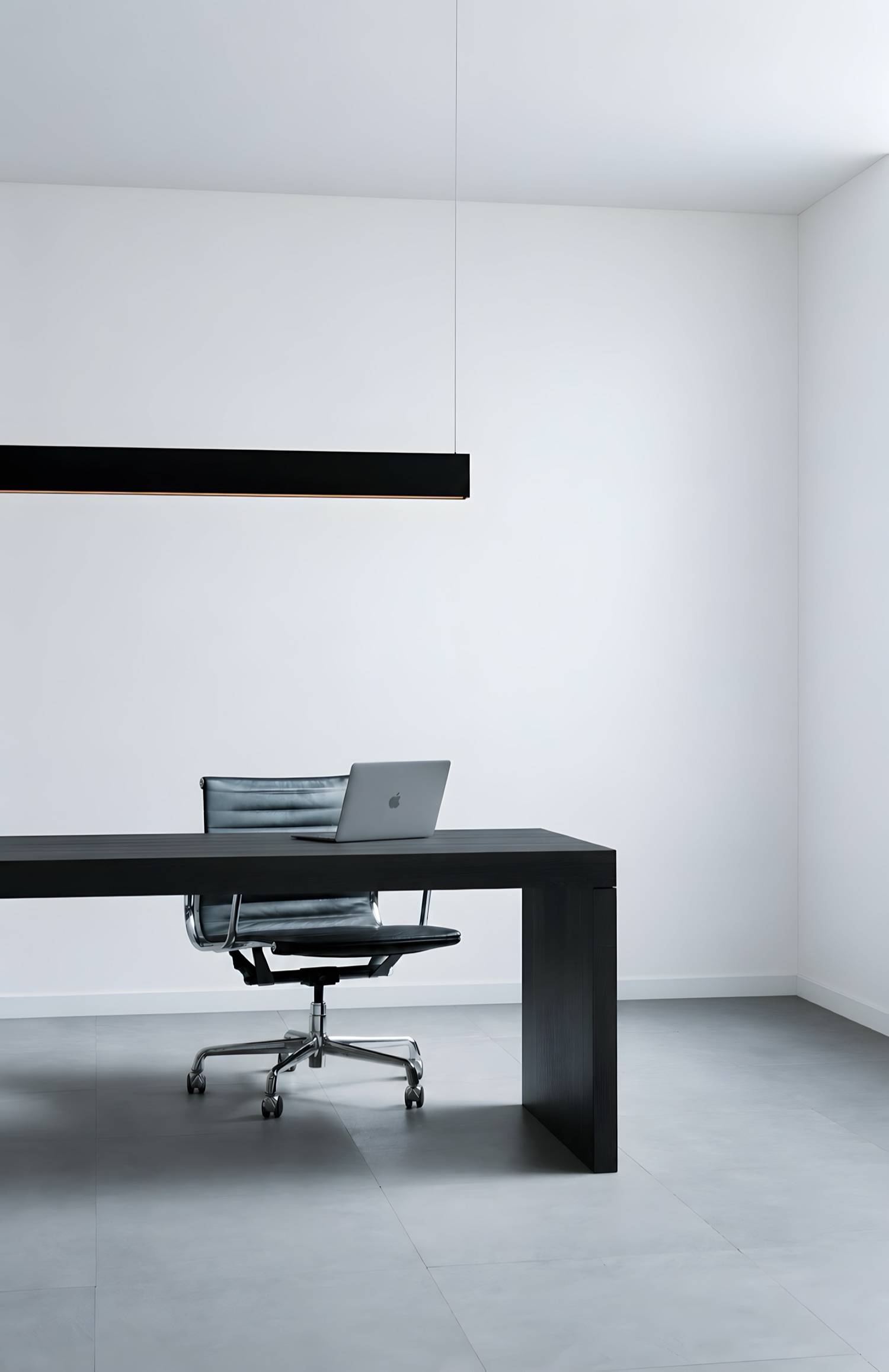An office with a black desk, the wall painted plain