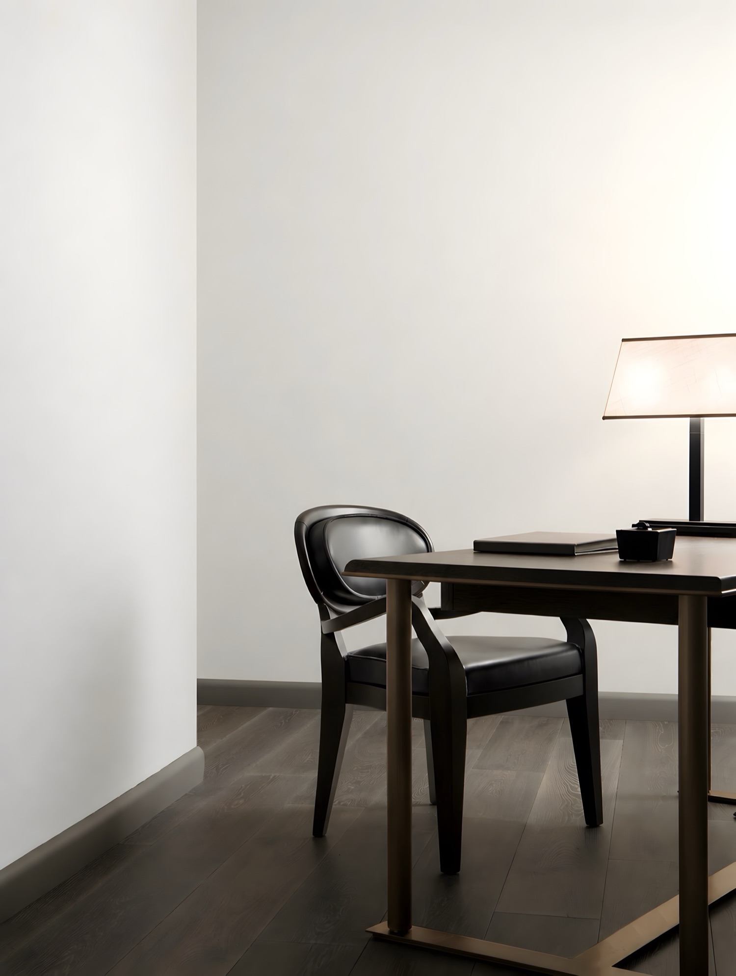 A study with a lamp and a desk, the walls painted plain