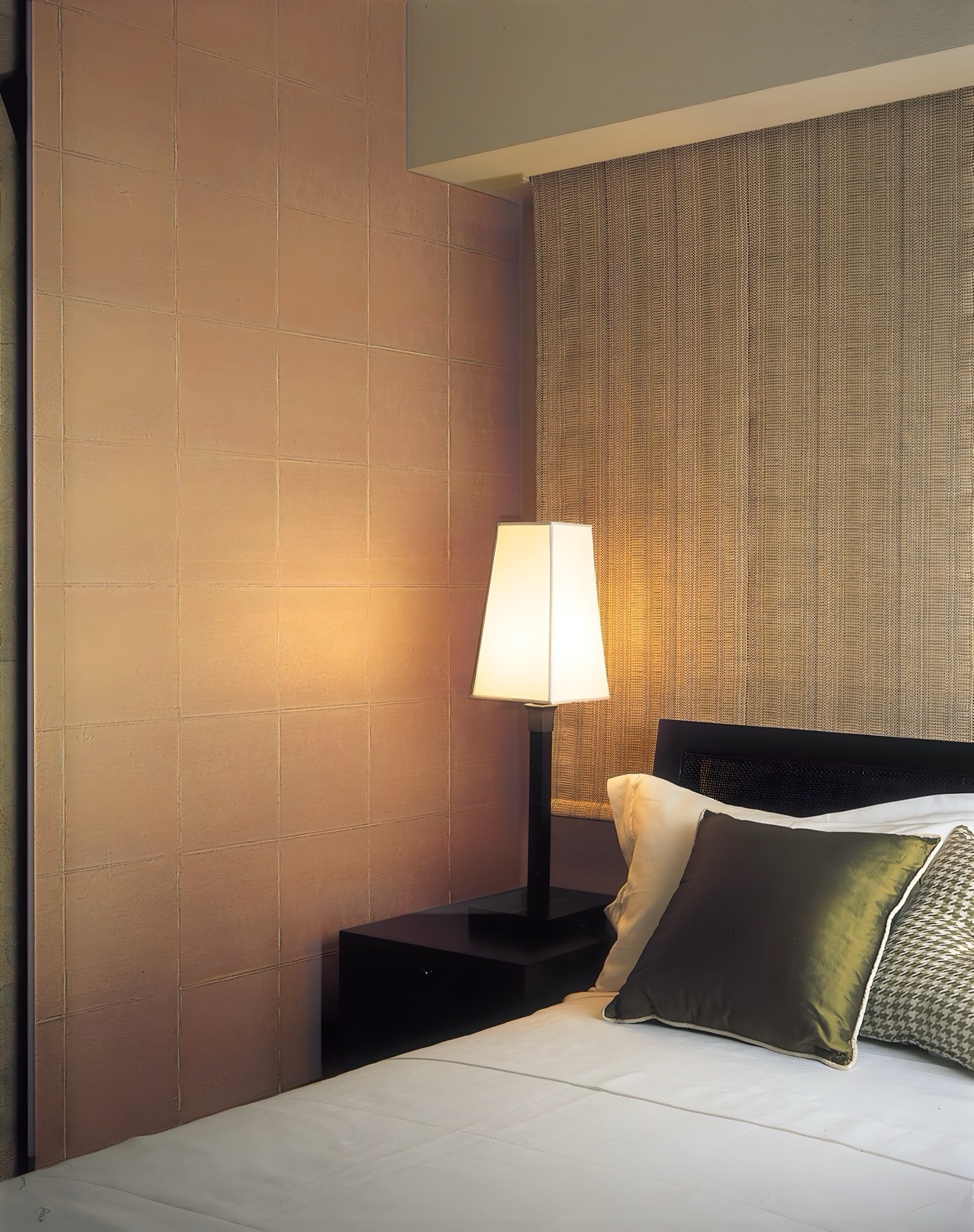 A bedroom wall in kiri, with a lamp