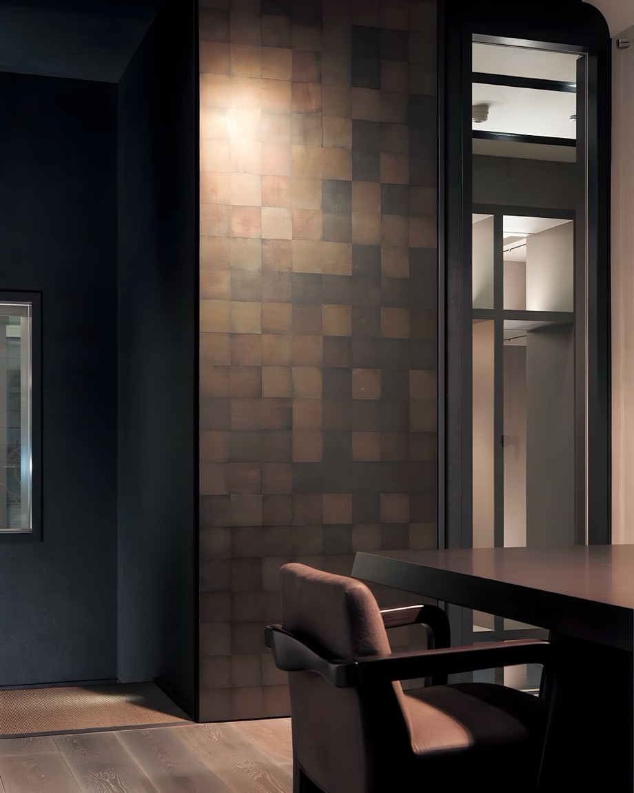 A copper leaf wall in a dark hallway