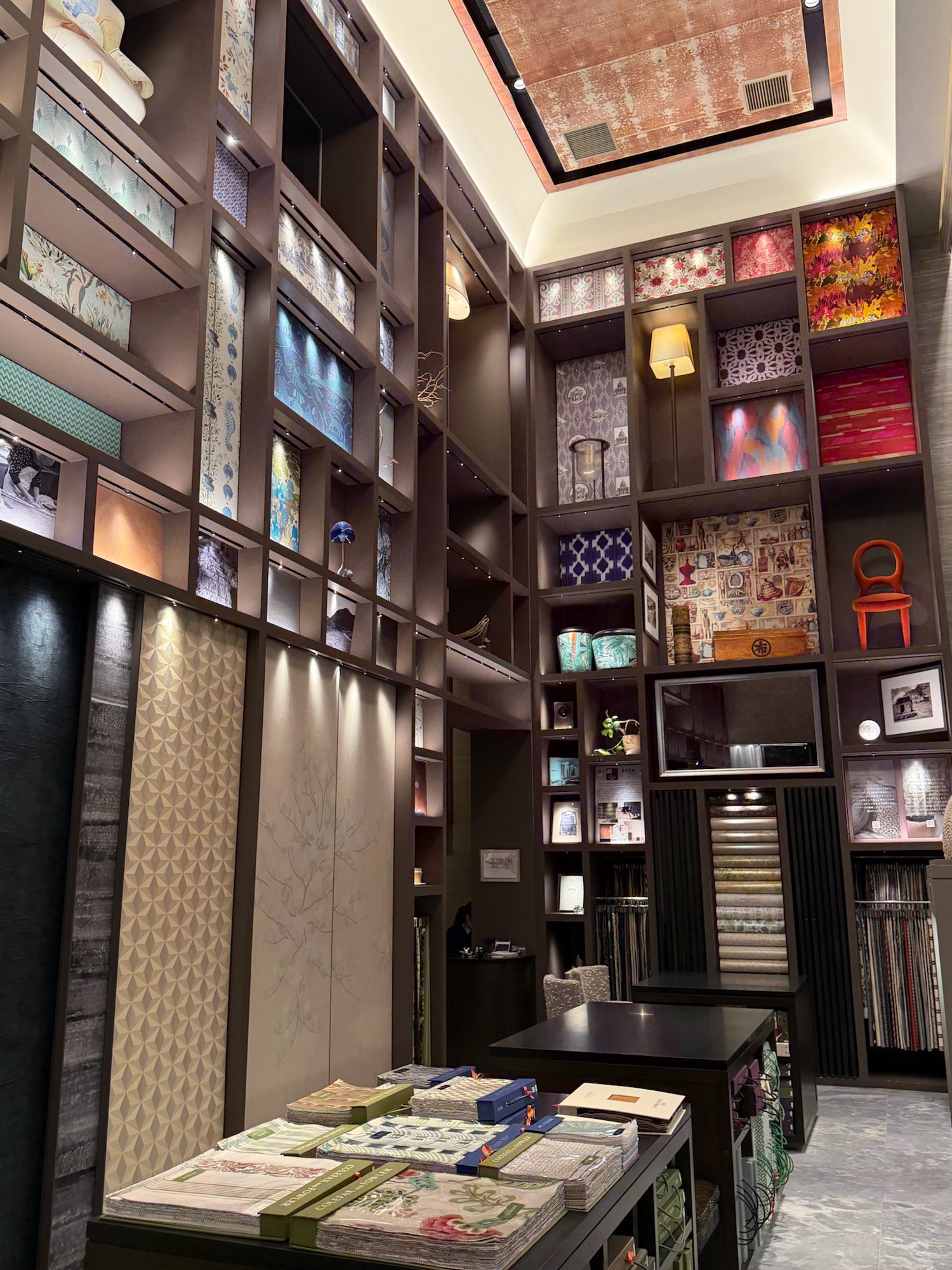 Inside tomita TOKYO: walls of wallcoverings and fabrics rising to a gilded ceiling